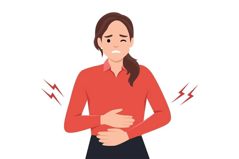 زنی که دچار علائم گوارشی است و با درد شکم، دستش را روی معده‌اش نگه داشته است 