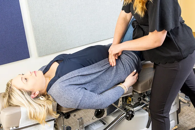 کایروپراکتیک در بارداری زن باردار روی تخت مخصوص در حال دریافت درمان کایروپراکتیک است