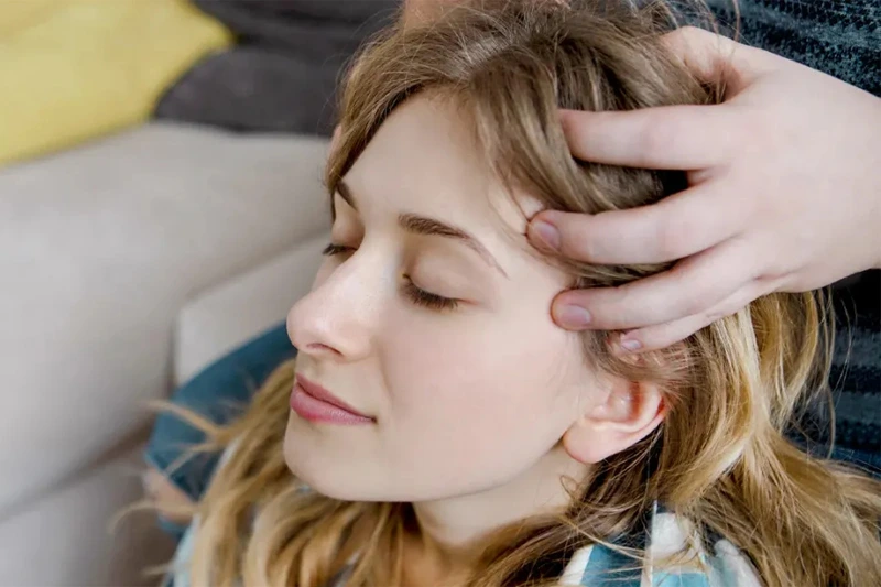 زن در حال نشستن و دریافت ماساژ و گوش دادن درباره فواید ماساژ و تأثیر آن در تسکین درد